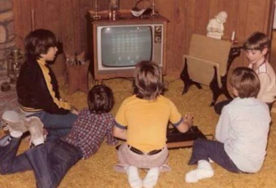 1980s kids playing video games in a living room