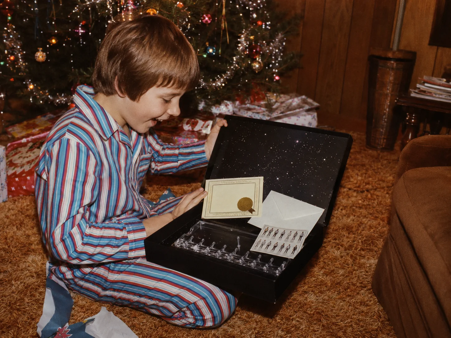Child opening the Star Wars Early Bird Certificate Package display stand on Christmas morning in 1977