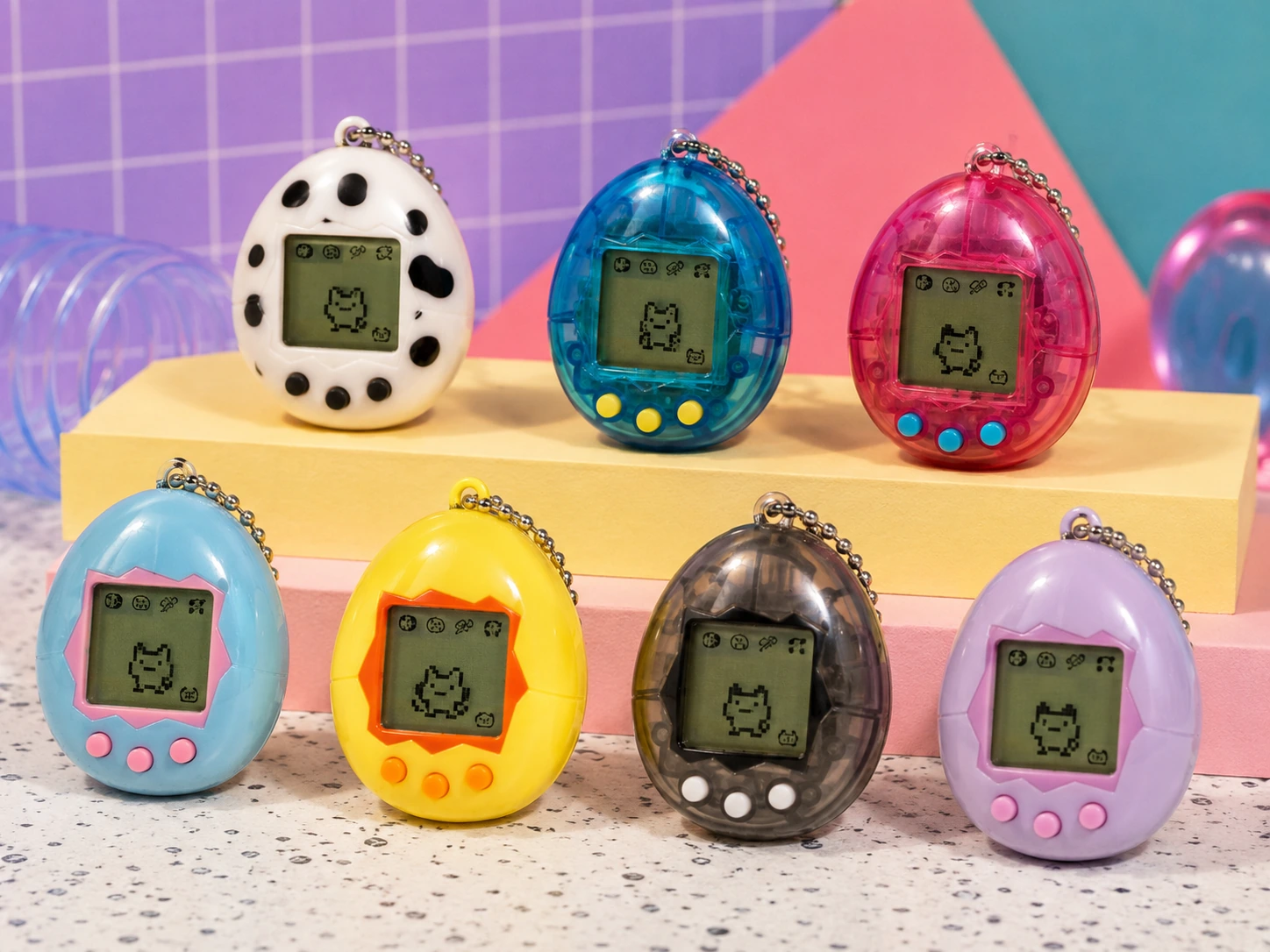 Several colorful 1990s egg-shaped digital pet keychains arranged for comparison