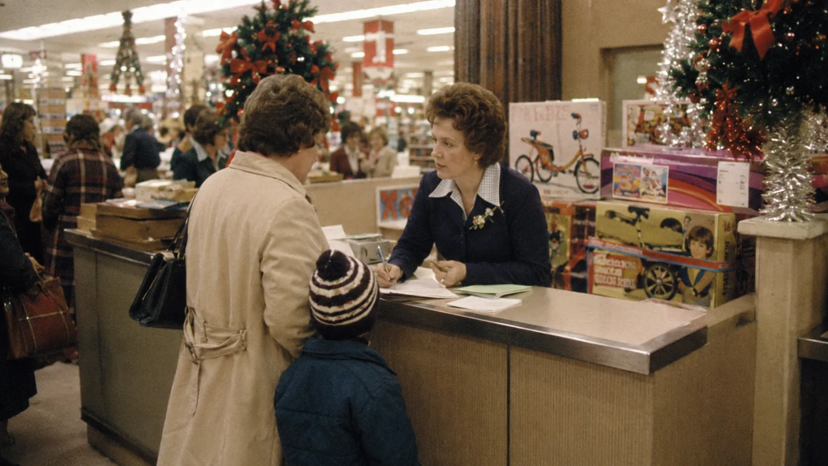 Parent using a department store layaway counter during the 1970s Christmas season