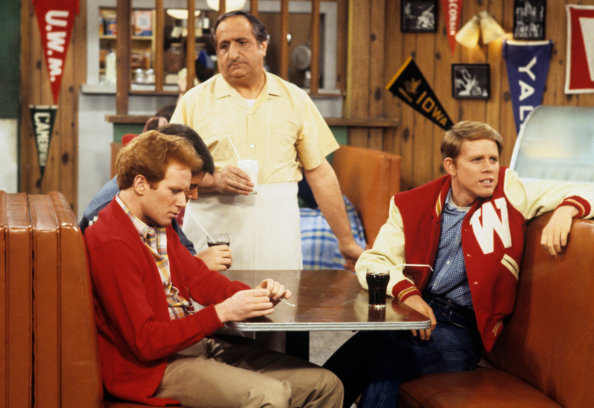 Richie Cunningham and friends sitting in a booth at Arnold's diner