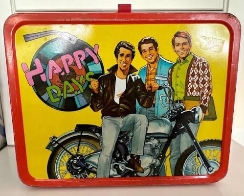 Vintage red Happy Days lunch box showing Fonzie, Richie and Potsie