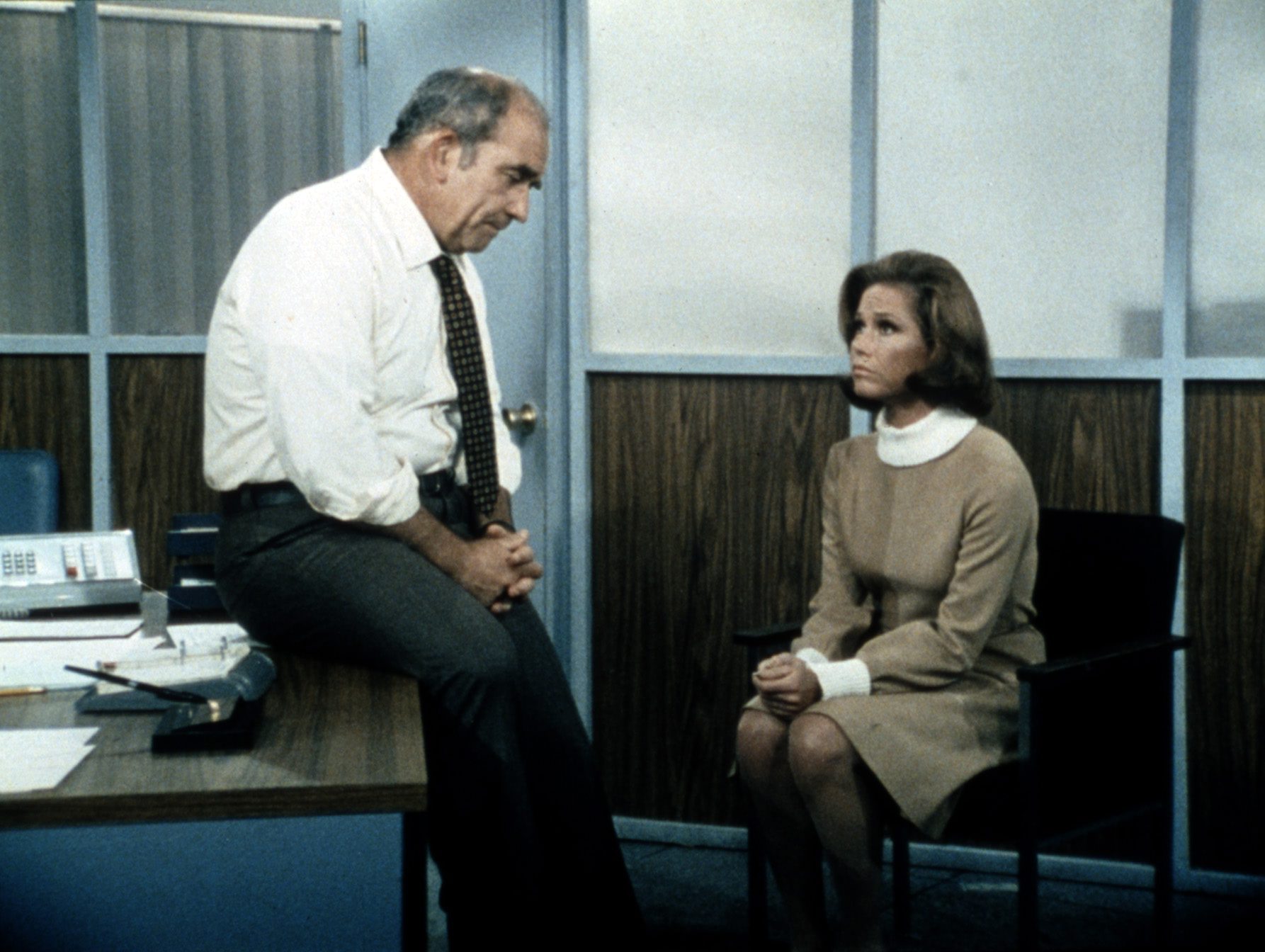 Mary Richards seated with Lou Grant in his WJM office