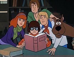 Fred, Daphne, Velma, Shaggy and Scooby-Doo examining a clue in the original 1969 cartoon