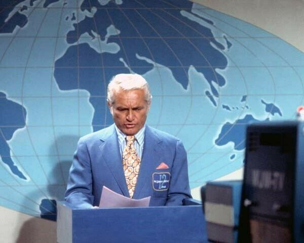 Ted Baxter seated at the WJM anchor desk