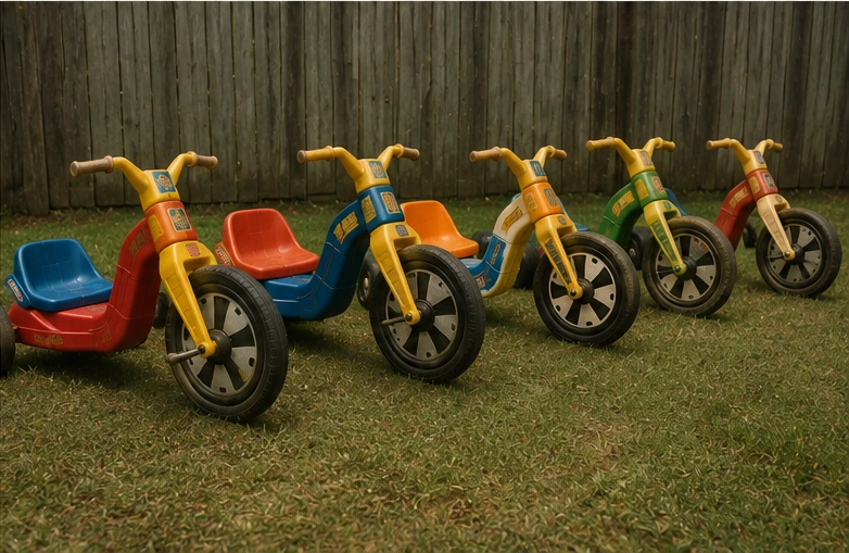 Row of differently colored low-riding plastic trikes inspired by the 1970s Big Wheel