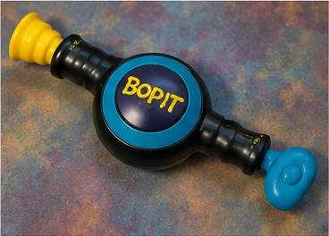 Black and blue 1990s-style handheld reaction game with twist and pull controls