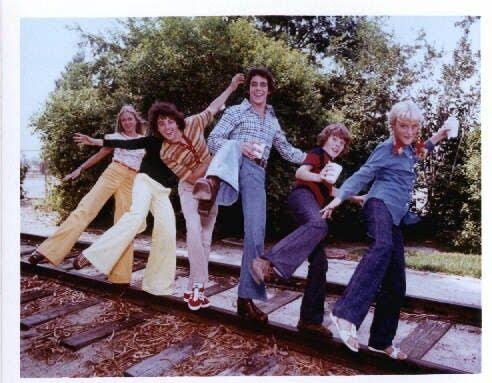 The six Brady children balancing together outdoors in a playful 1970s cast photograph