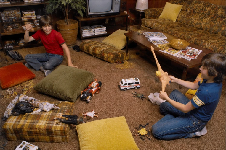 Cluttered 1970s family room during a complete Stretch Armstrong play session with cushions and toys