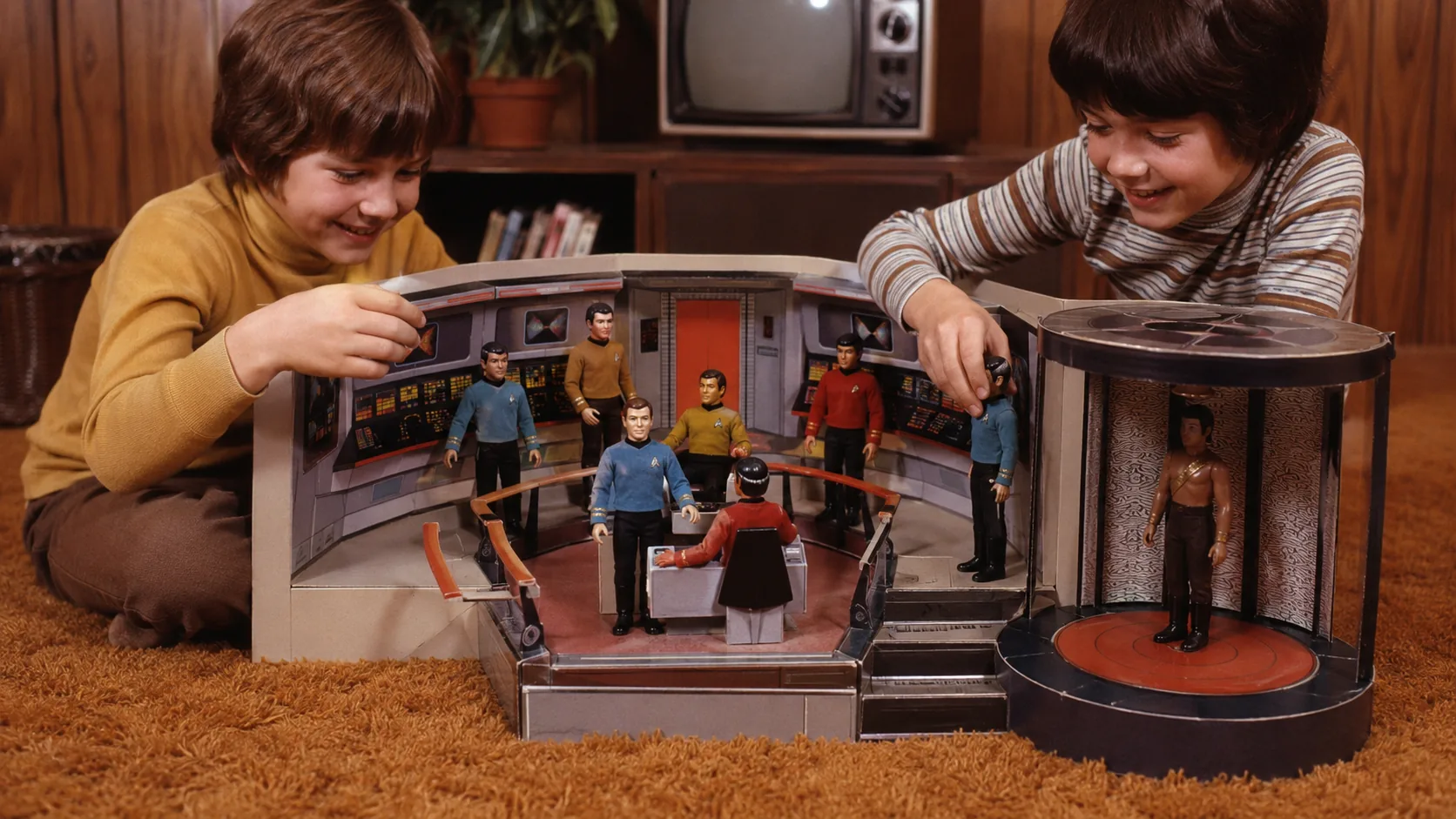 Children playing with Mego Star Trek figures inside a cardboard Enterprise bridge and spinning transporter playset