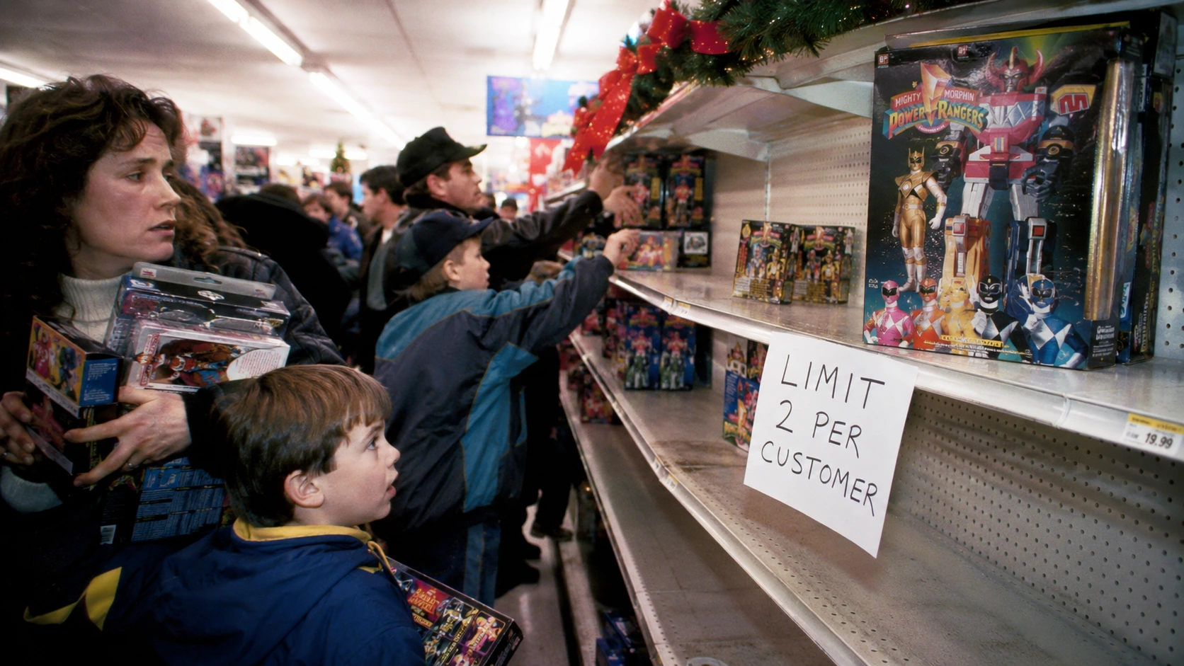 Parents and children crowding a nearly empty Power Rangers toy display during Christmas 1993