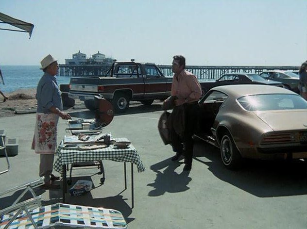 Jim Rockford beside his gold Firebird at a Southern California beach location