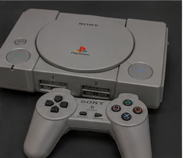 Original gray Sony PlayStation console and controller from the 1990s