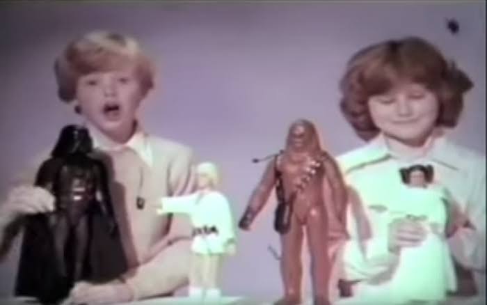 A late-1970s toy-commercial scene featuring children operating action figures and spacecraft