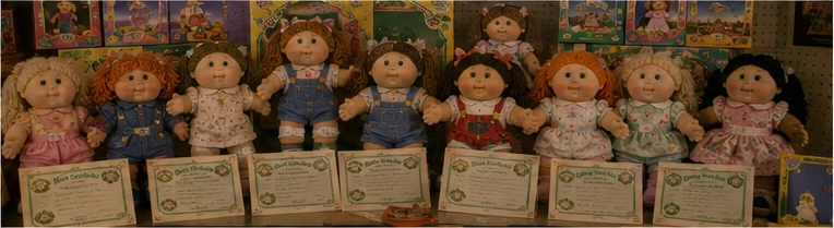 Collector display of boxed and loose vintage yarn-haired dolls with original certificates and preserved packaging