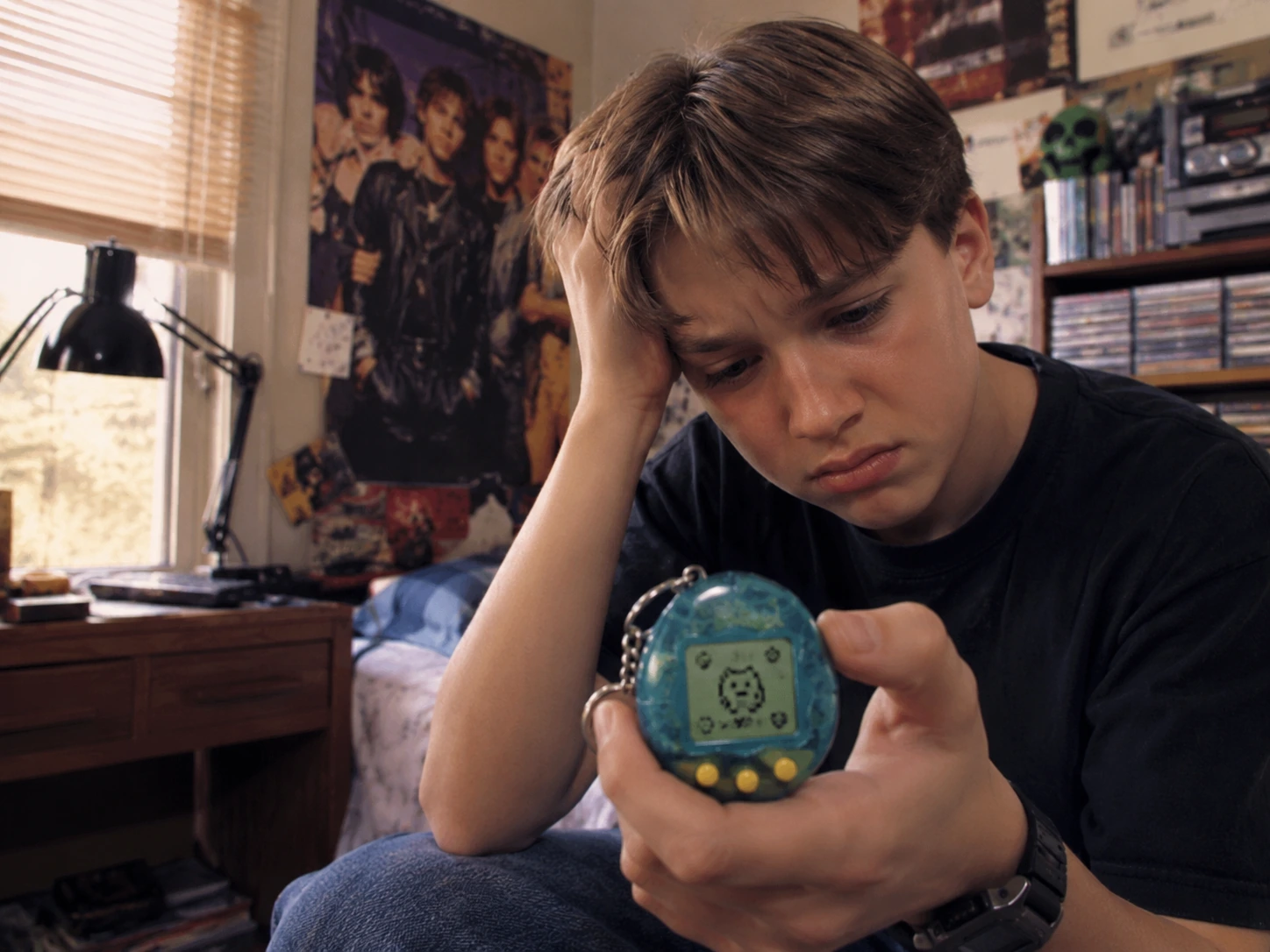 Worried child studying a digital pet screen in a 1990s bedroom