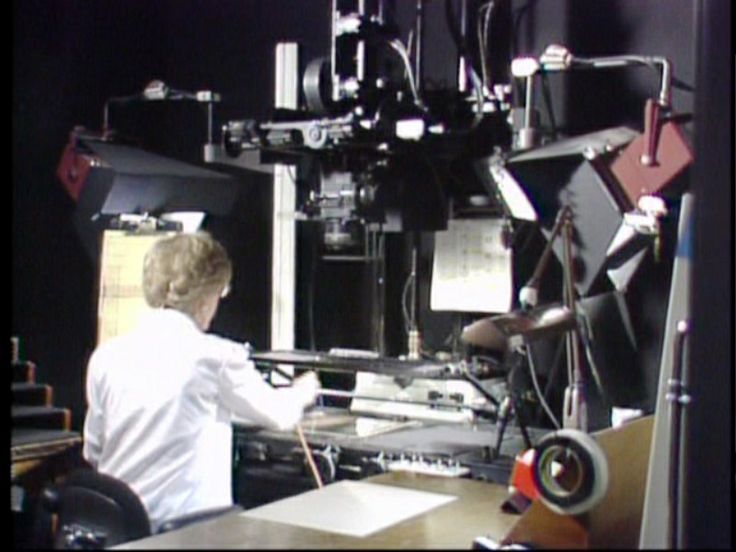 Animation camera operator working with cels and exposure sheets