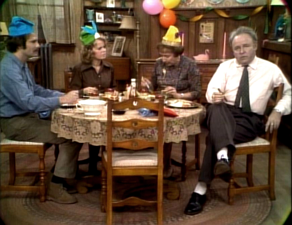 Archie, Edith, Mike and Gloria gathered around the table in Meet the Bunkers