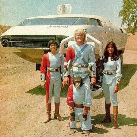 Ark II cast standing in front of the futuristic Ark II vehicle
