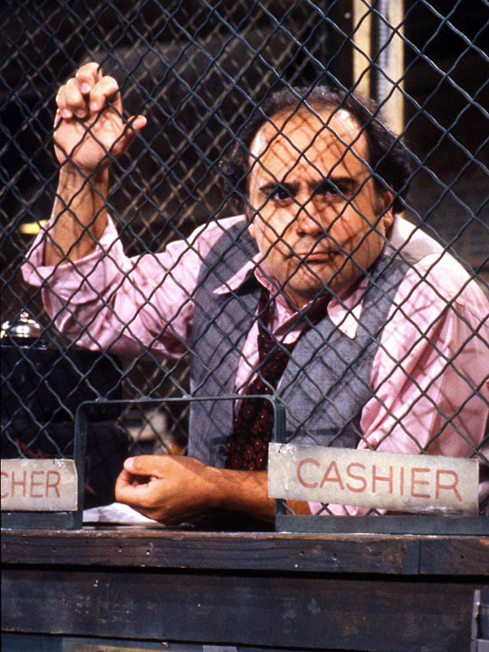 Danny DeVito as Louie De Palma in the Sunshine Cab dispatch cage