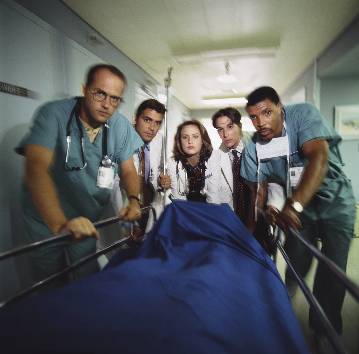 ER cast working in a crowded emergency room